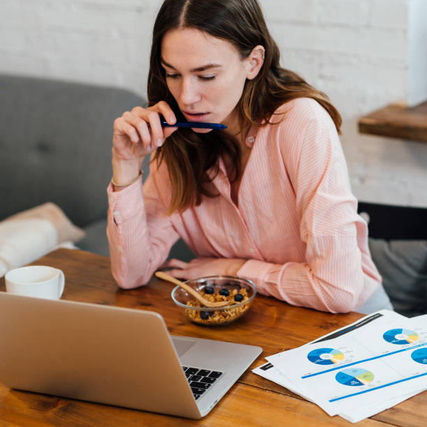 Young woman at home at her desk with a laptop.