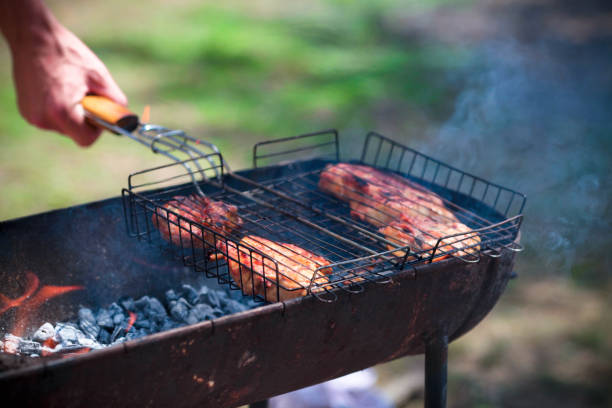 The male hand prepares a barbecue from chicken meat on a brazier.