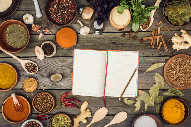 Top view of notebook for recipes with spices on a table